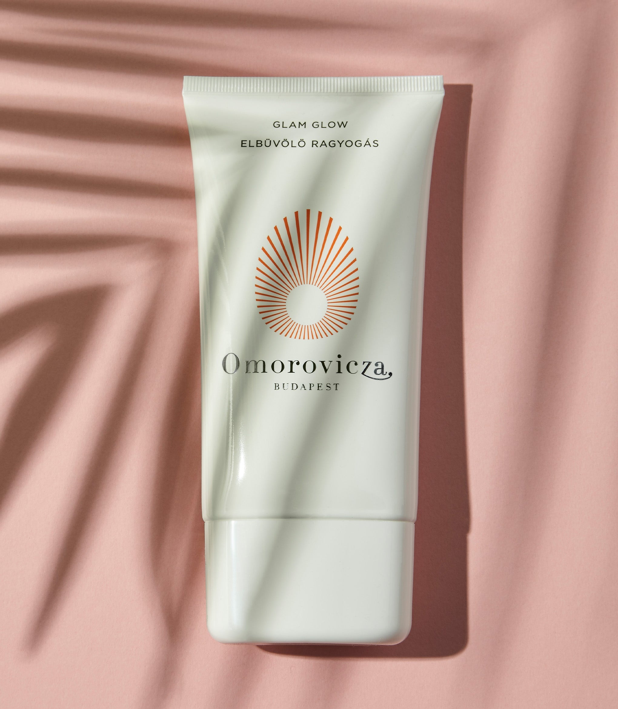 A tube of hydrating, citrus-scented self-tanner Glam Glow on a pink background.